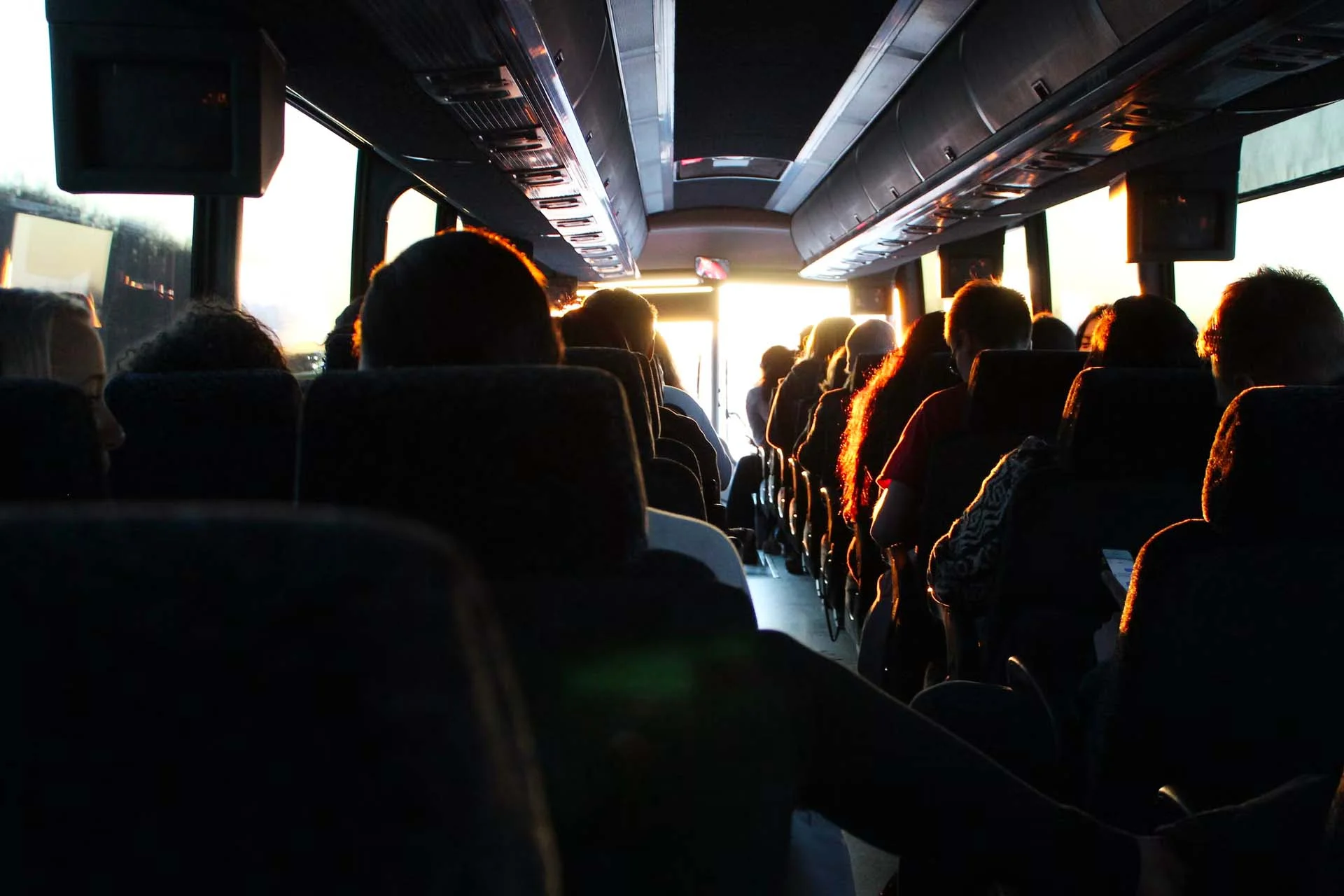 Passengers in bus driving into the sun